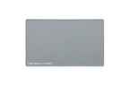 A rectangular ash gray beauty mat with rounded corners and the text 'THE BEAUTY MAT' printed in white at the bottom left, shown on a plain white background.