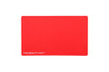 A bright cherry red rectangular silicone beauty mat with rounded corners and the white text 'THE BEAUTY MAT' printed in the bottom-left corner, shown on a plain white background.